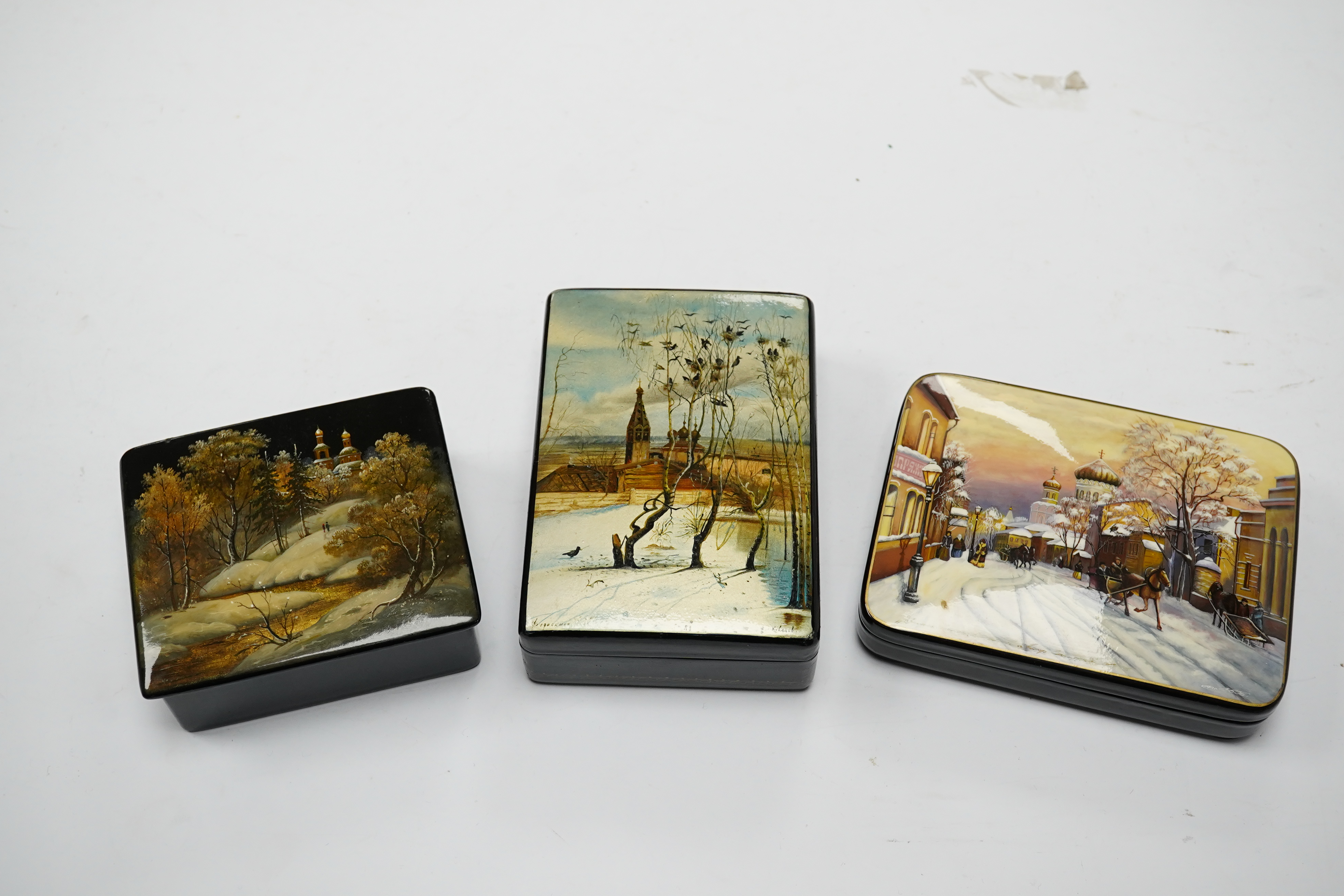 Three late 19th/early 20th century Russian lacquer boxes, decorated with snow scenes, largest 13.5cm. Condition - good